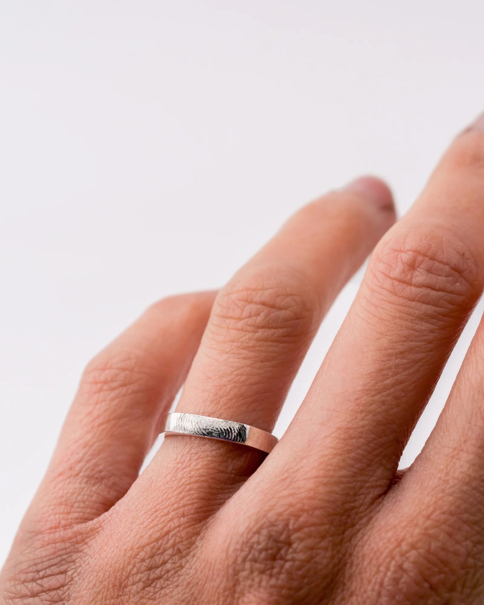 Bague fine type alliance ruban en argent avec empreinte digitale.