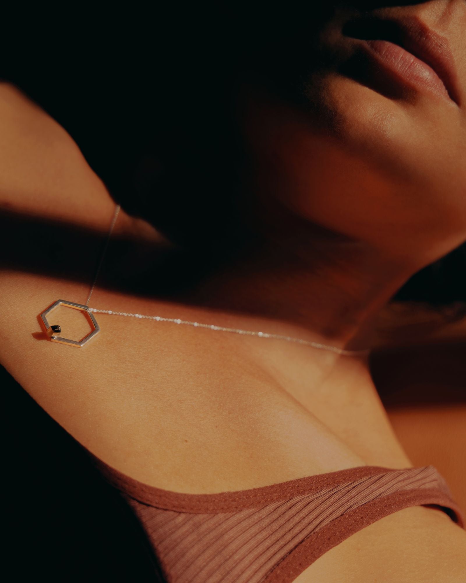 Photo portée en collier avec jeu d'ombre d'une bague collier éthique modèle Solitaire en argent et pyrite de France.