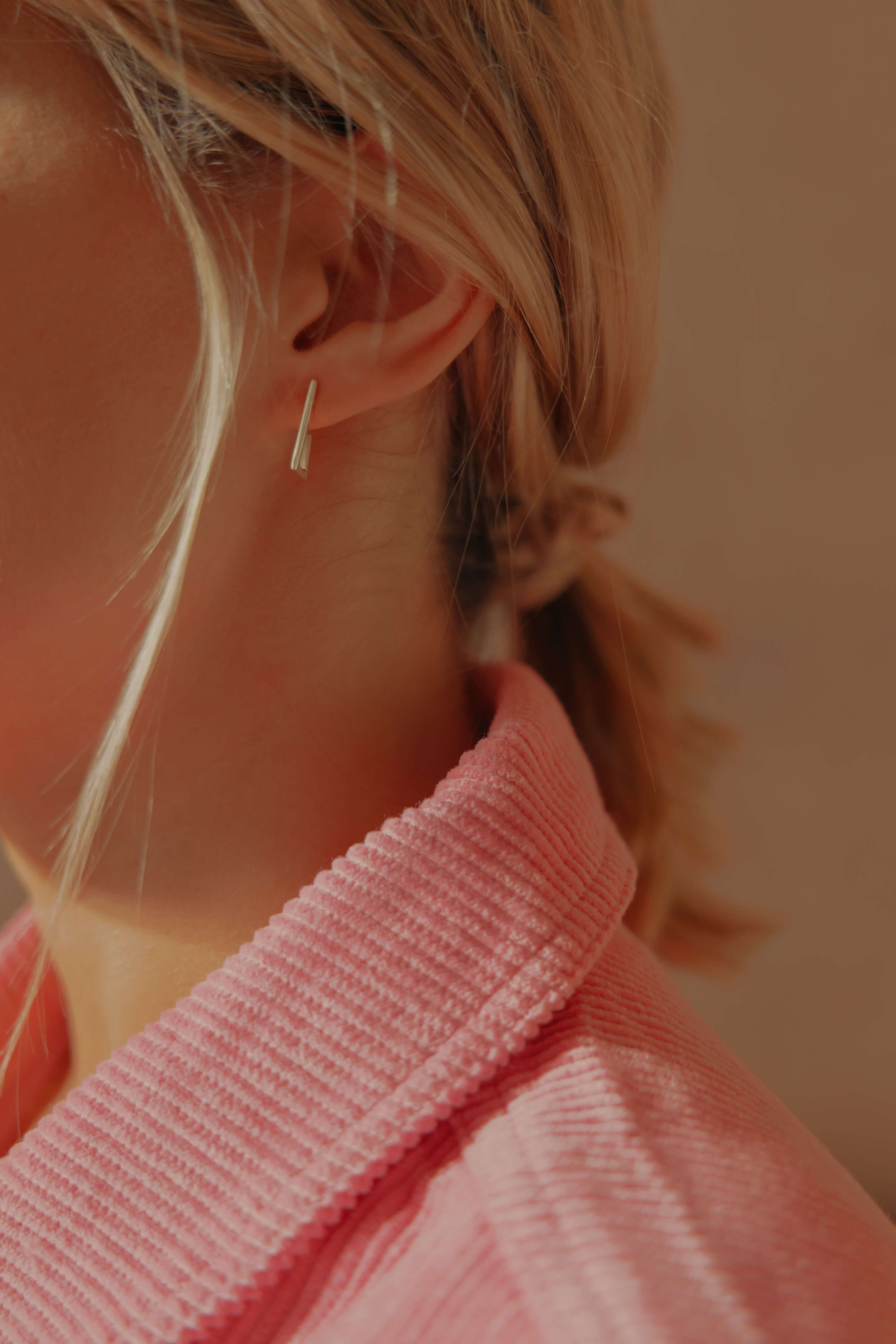 Photo portée d'une boucle d'oreille éthique modèle Mouvement en or blanc labellisé.