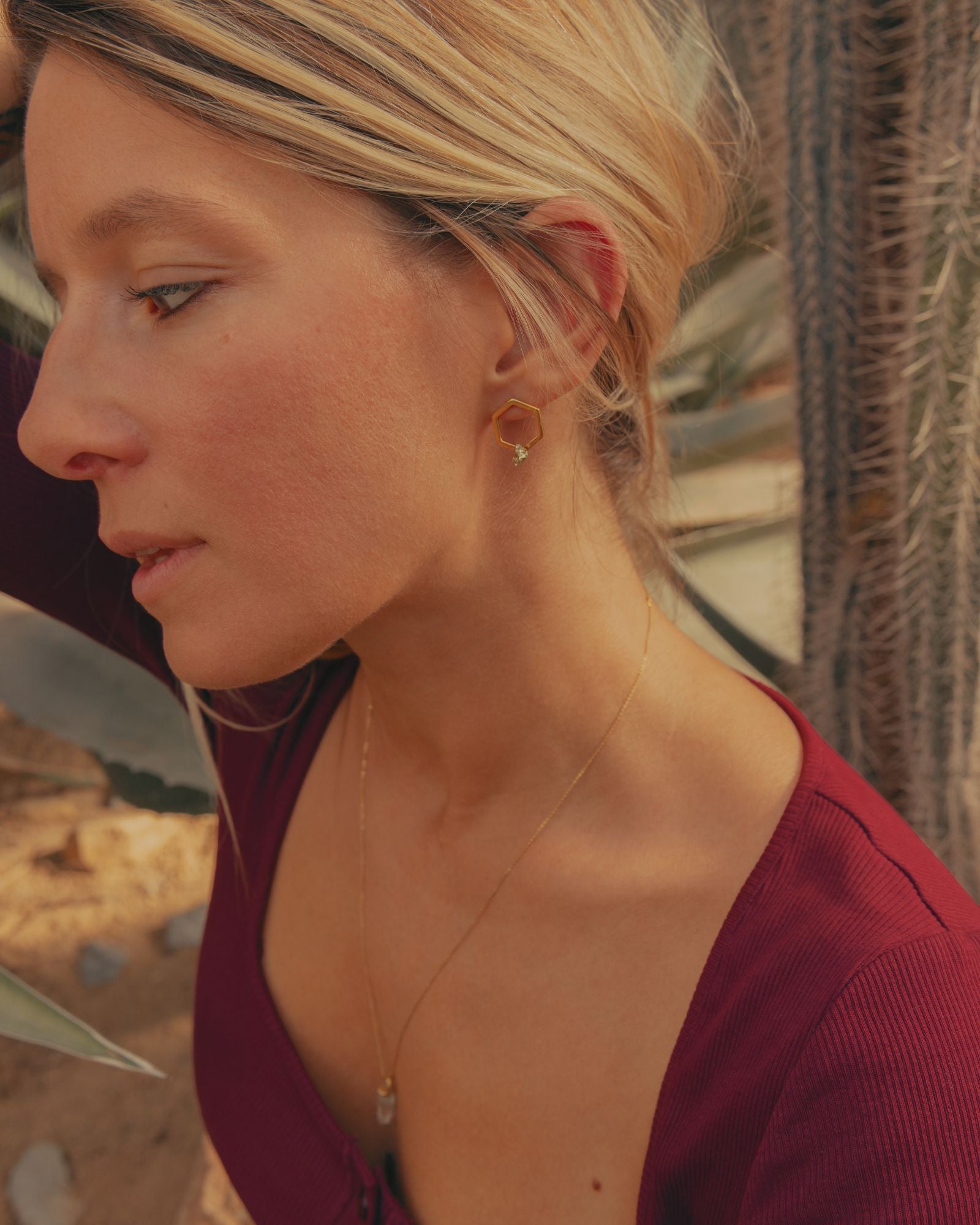 Photo portée d'une paire de boucles d'oreilles éthiques modèle Solitaire 14 en vermeil et pyrite de France.