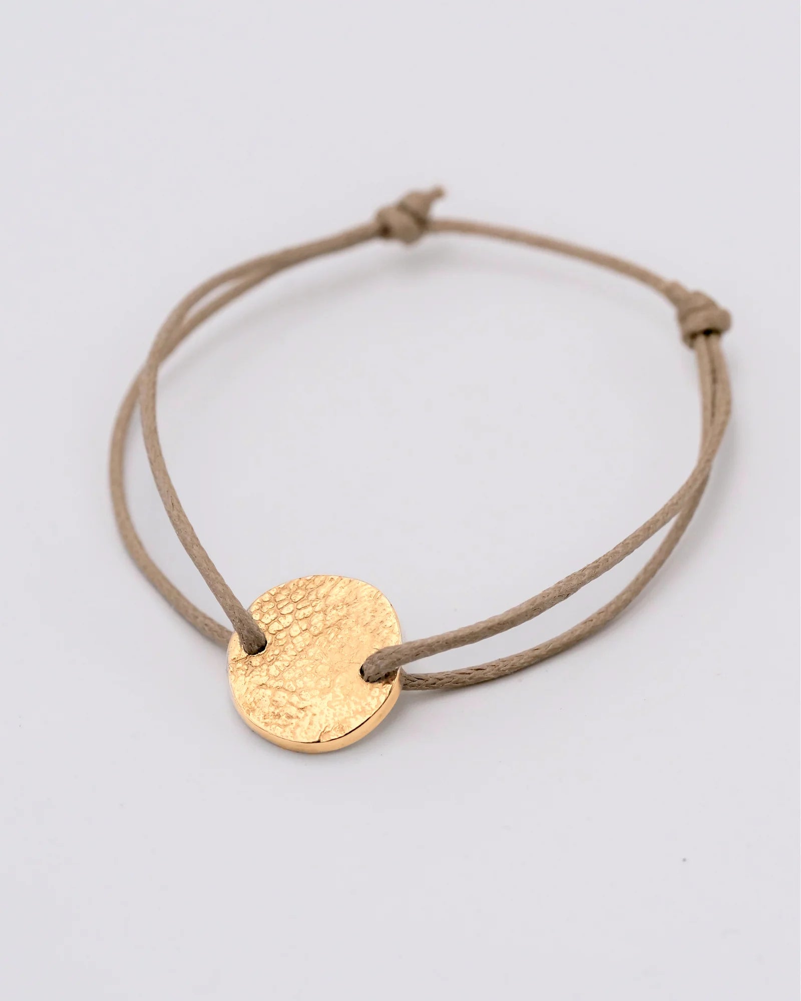 Bracelet rond vermeil avec empreinte animale sur cordon sable.