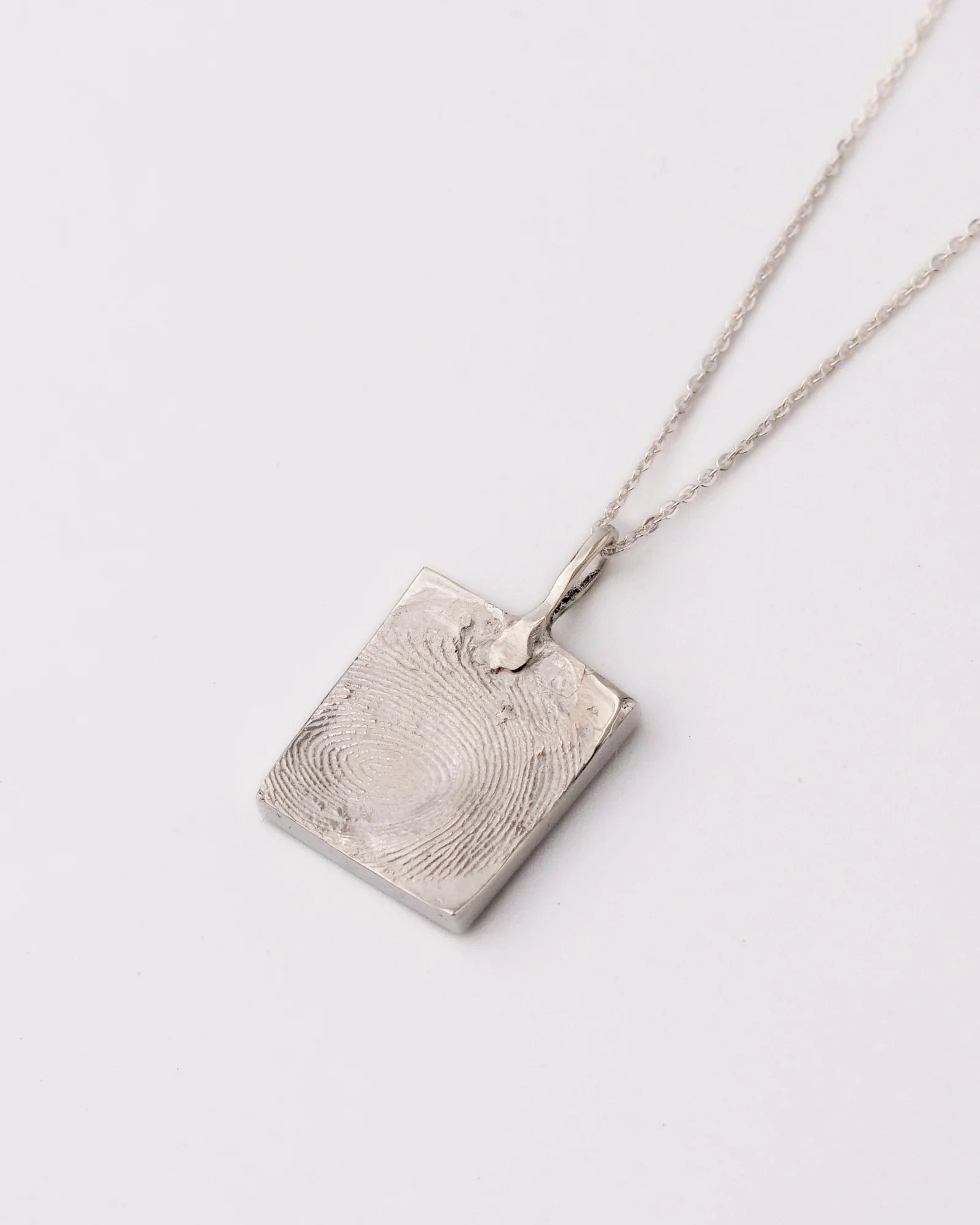 Collier avec pendentif carré en argent avec empreinte digitale sur chaine.