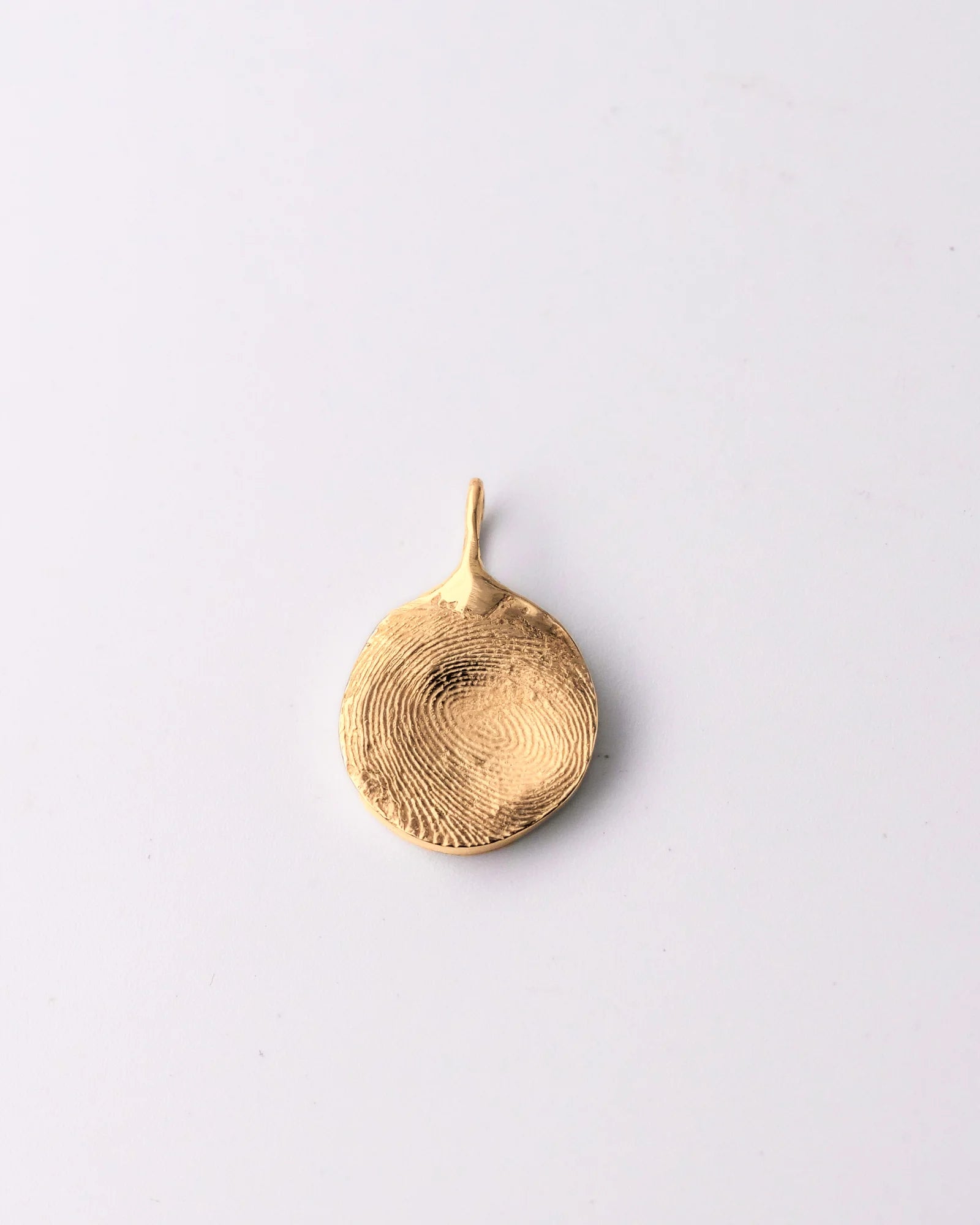Pendentif rond en vermeil avec empreinte digitale.