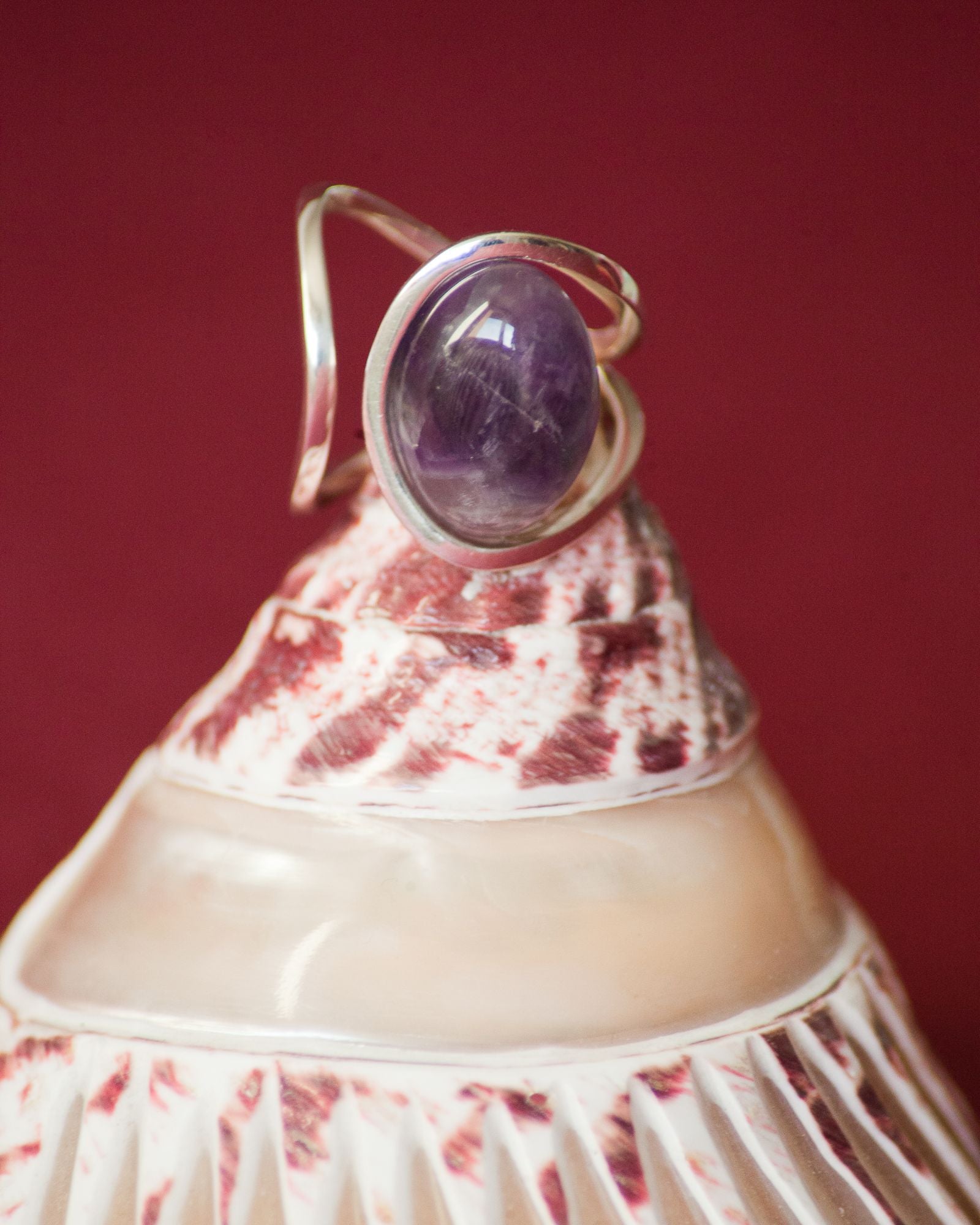 Bague éthique modèle "sororité" en collaboration avec une association en argent et améthyste de France sur un coquillage et fond bordeau