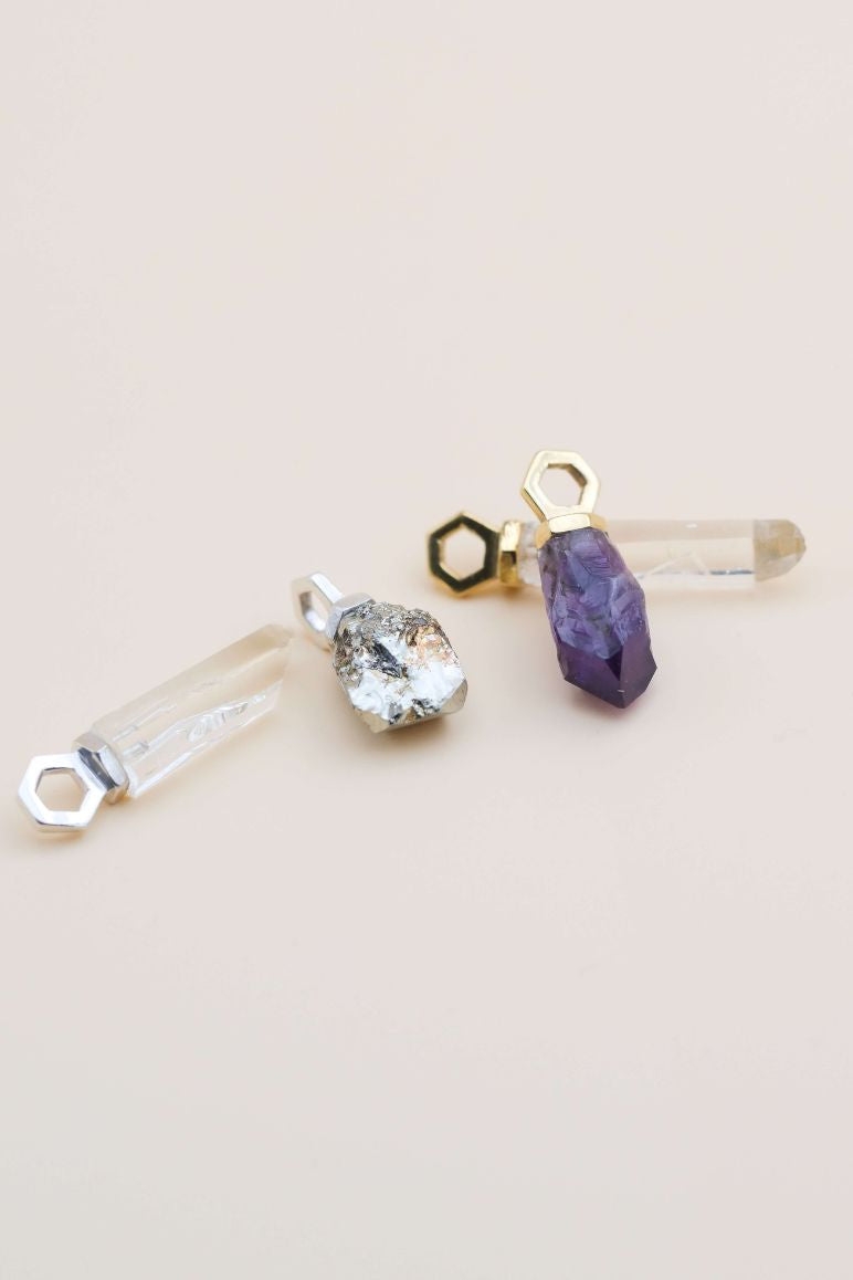 4 pendentifs éthiques modèles Infime avec pierres fines de France, en argent et vermeil, sur fond beige