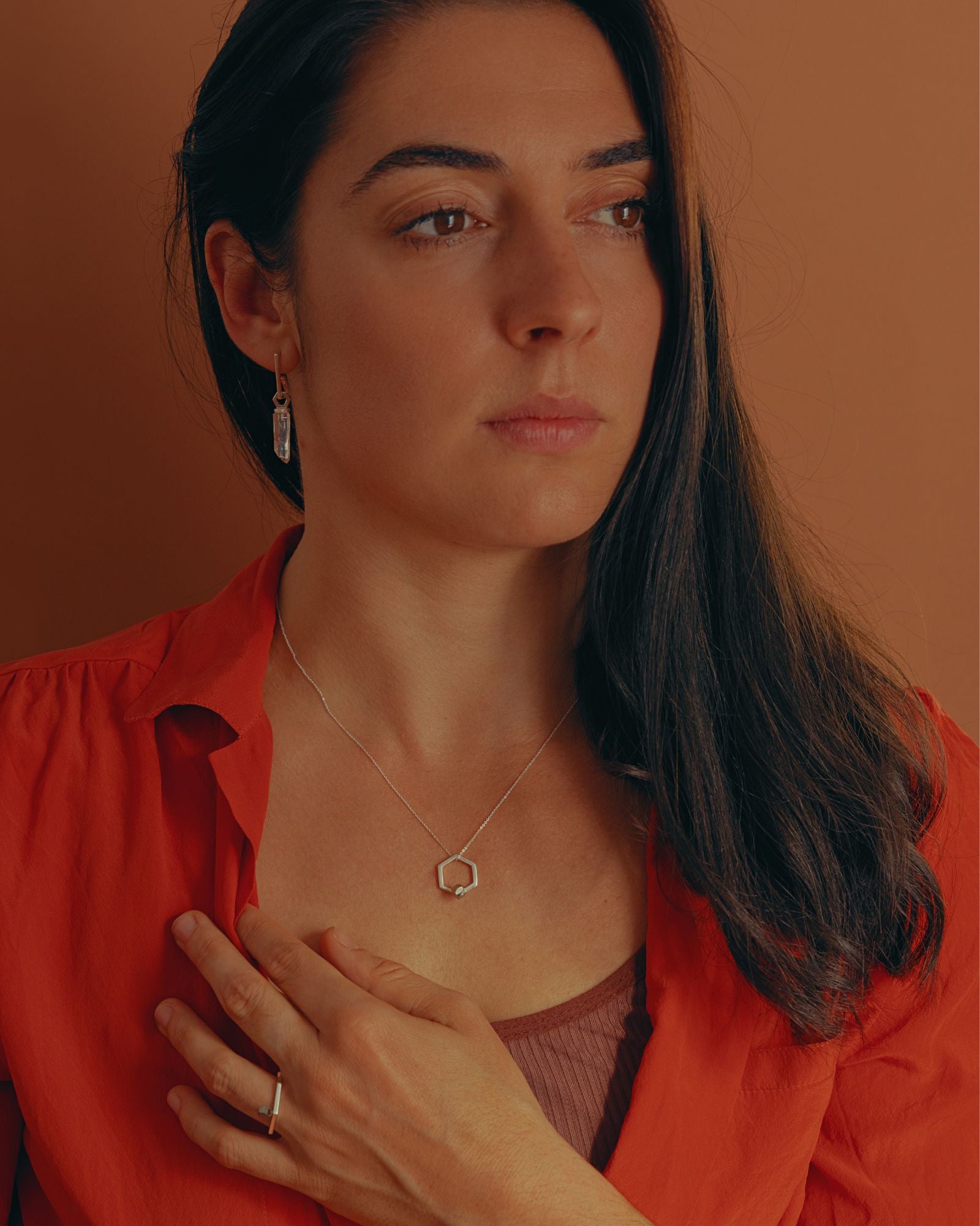 Photo portée à la main d'une bague pendentif éthique, modèle Solitaire en argent et pyrite de France.