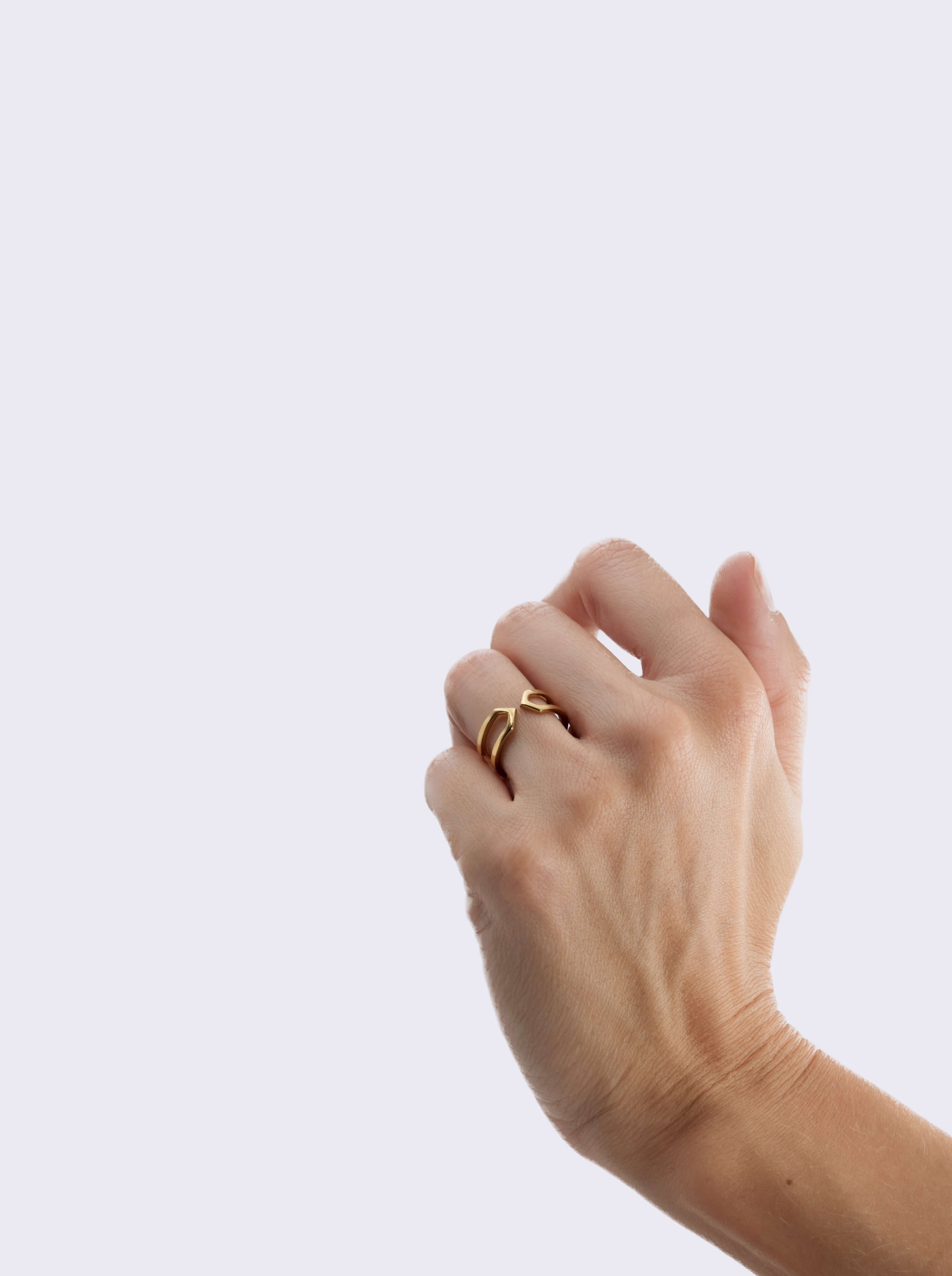 Bague Bijou d'oreille Dualité Fine Vermeil portée à la main sur fond blanc.