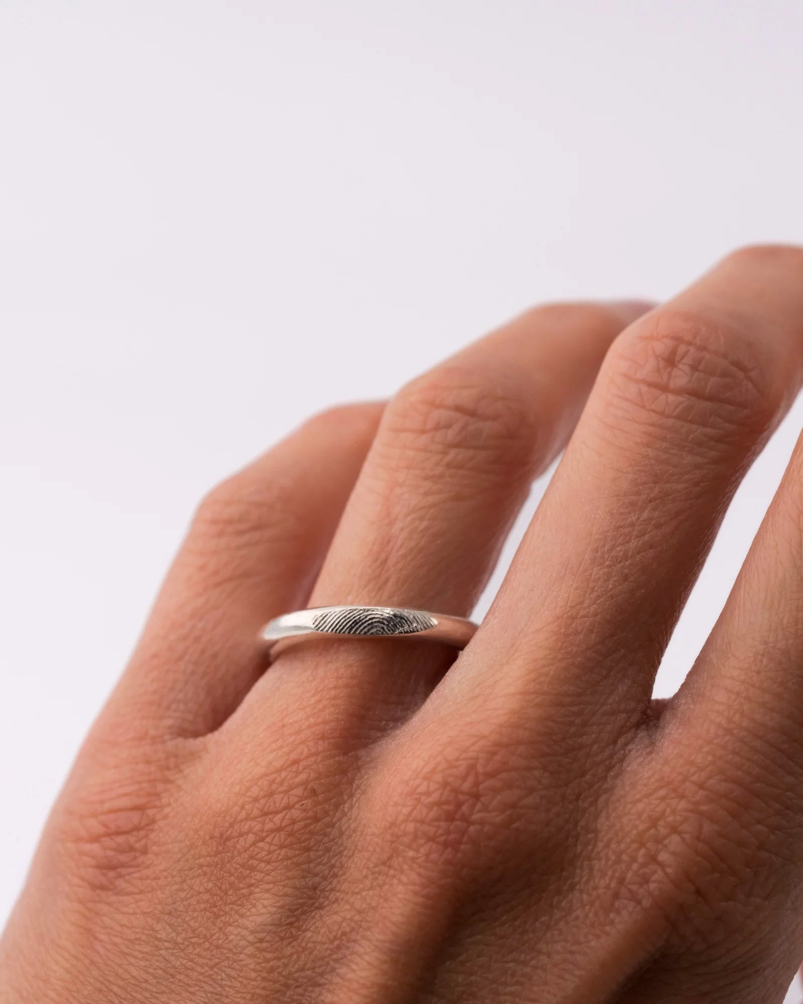 Bague et earcuff en argent avec empreinte digitale, portée.