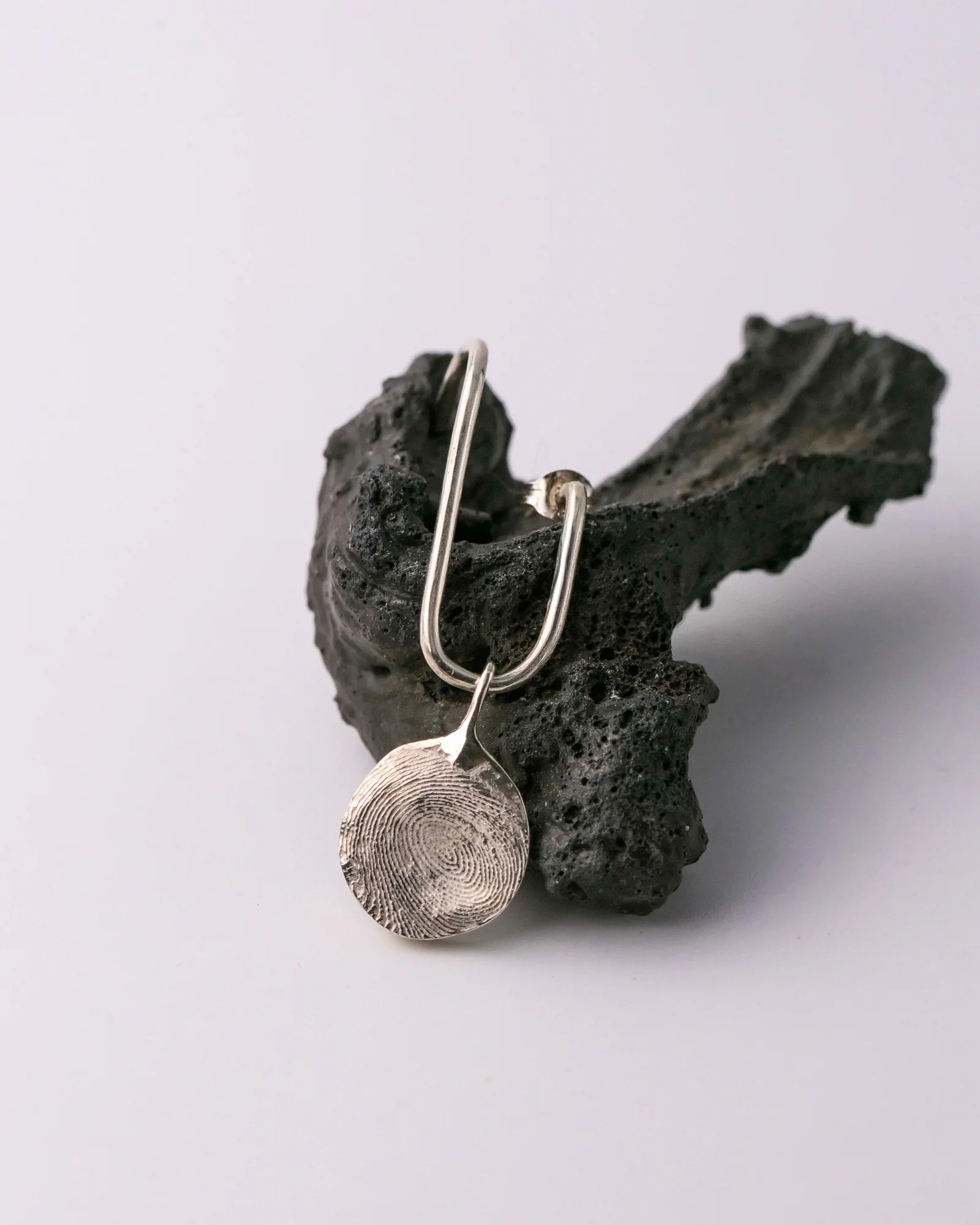 Boucle en argent permettant de porter des pendentifs et des bagues, présenté avec un pendentif rond.