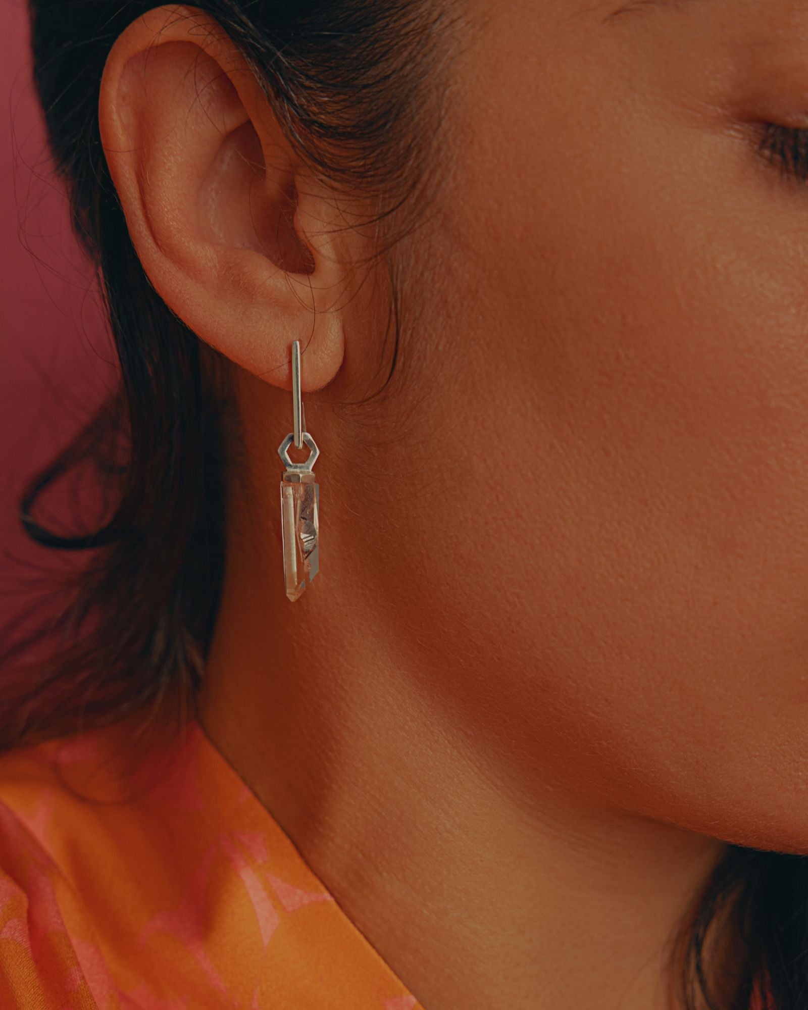 photo portée à l'oreille sur une boucle d'un pendentif éthique made in france modèle Infime en argent labellisé et pierre quartz français.