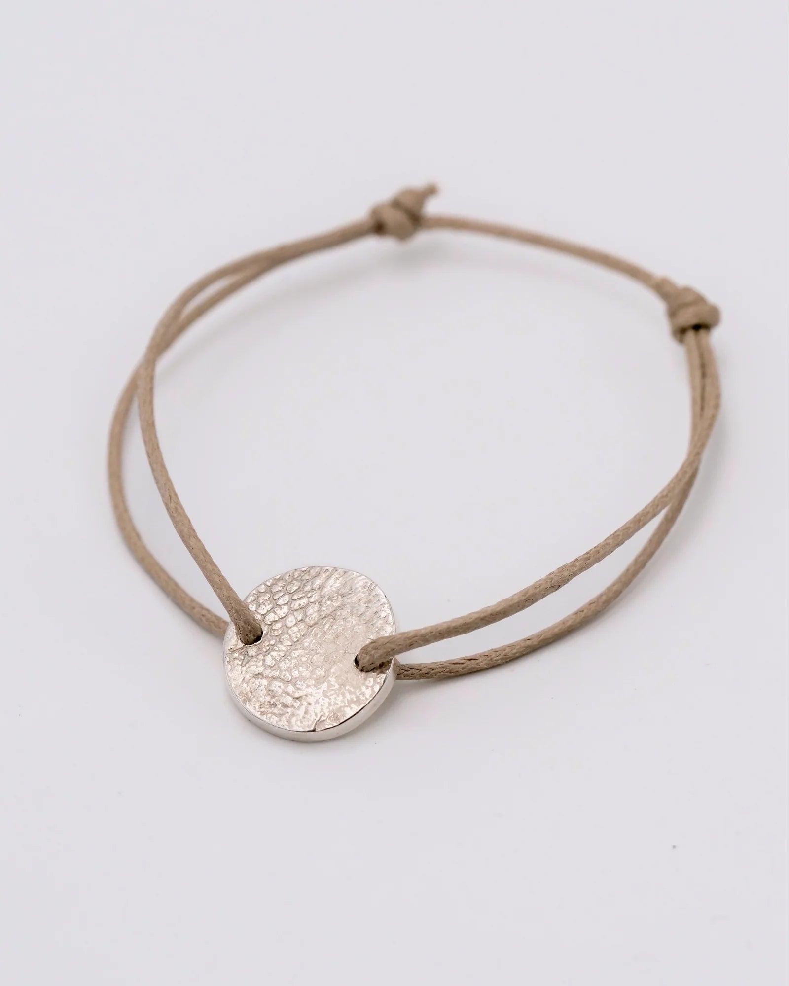 Bracelet cordon avec médaille ronde en argent avec empreinte animale zoomé.