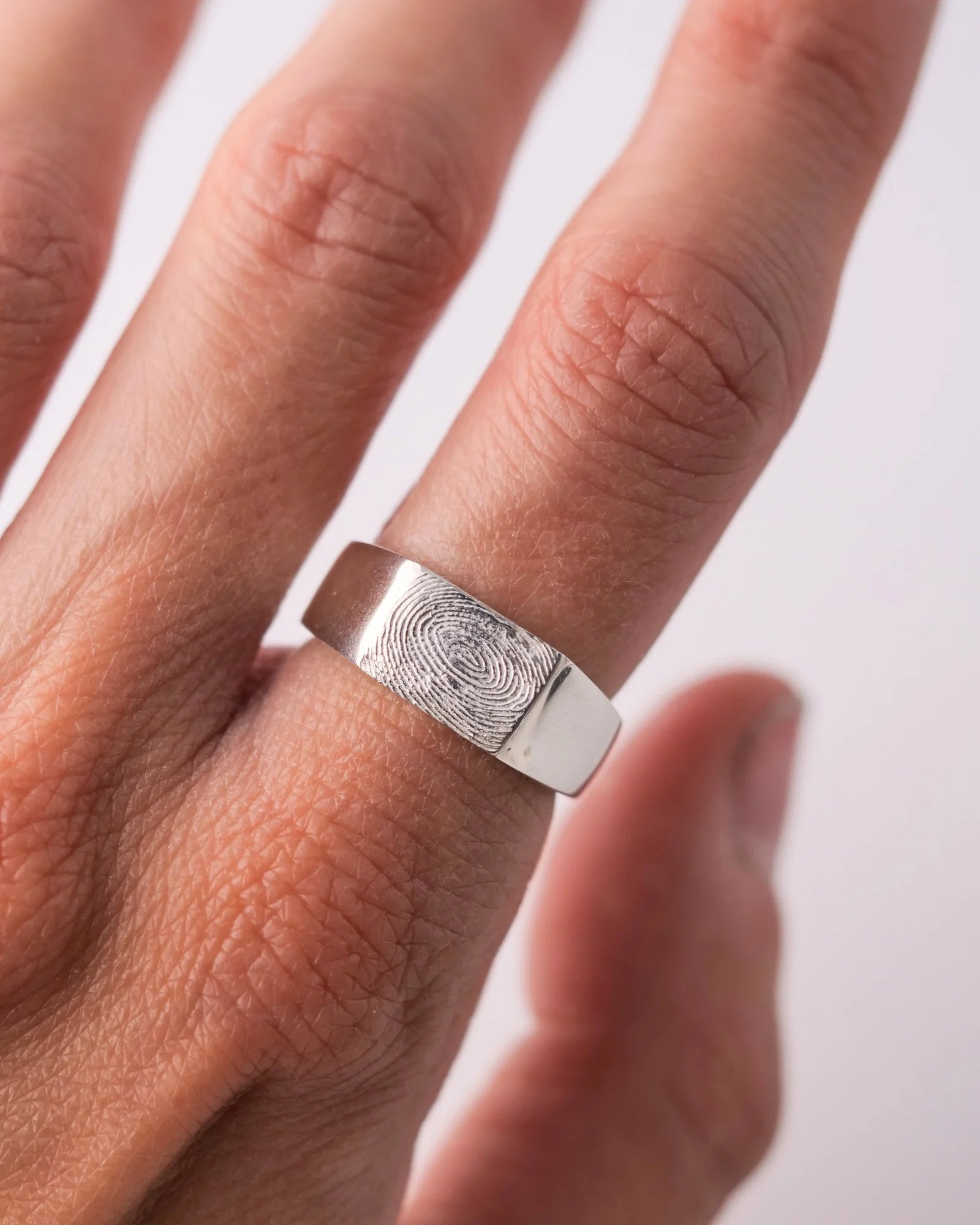 Chevalière large en argent avec empreine digitale portée.