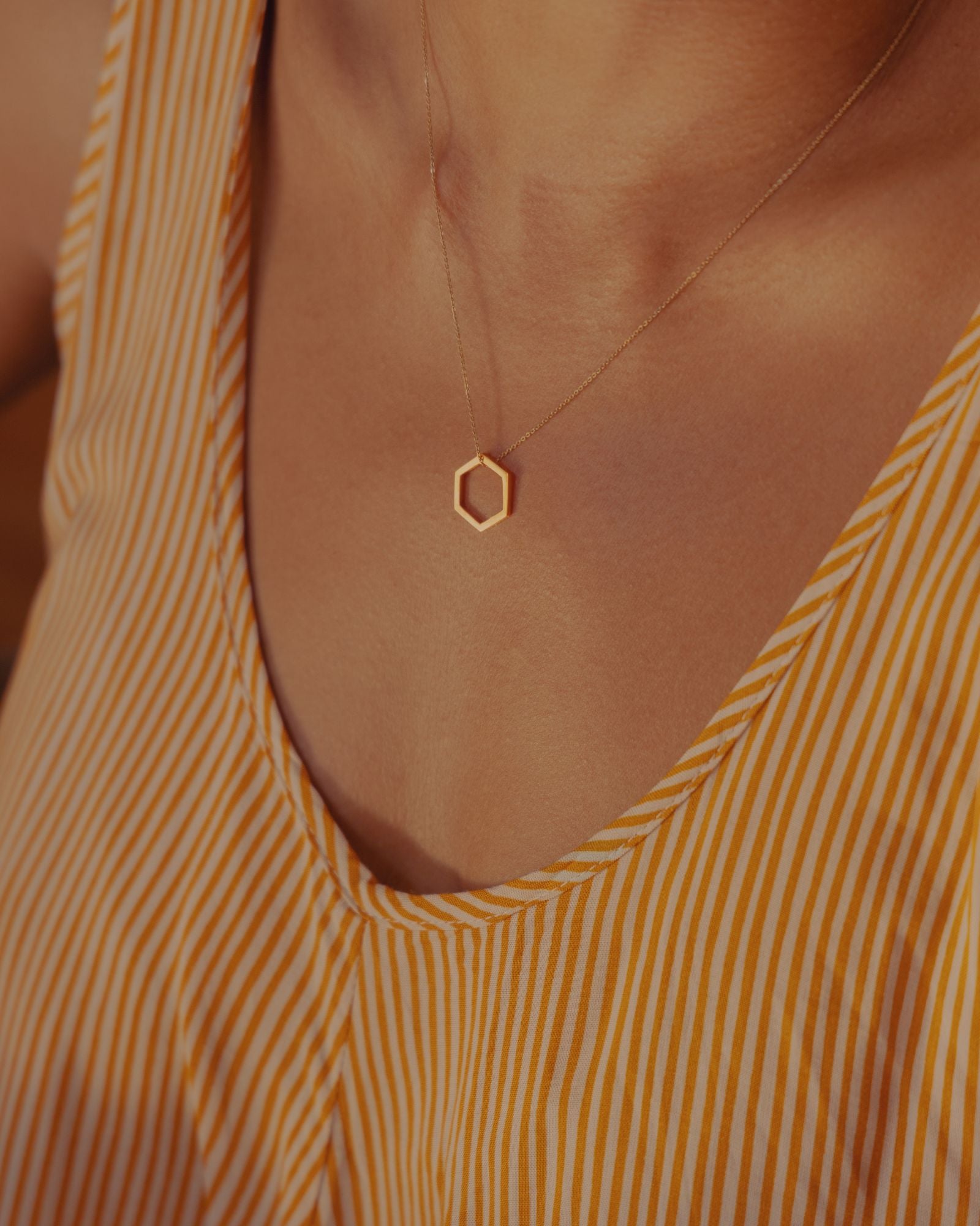 Photo portée d'un pendentif éthique porté sur une chaine, pendentif modèle Essentiel en or jaune labellisé.