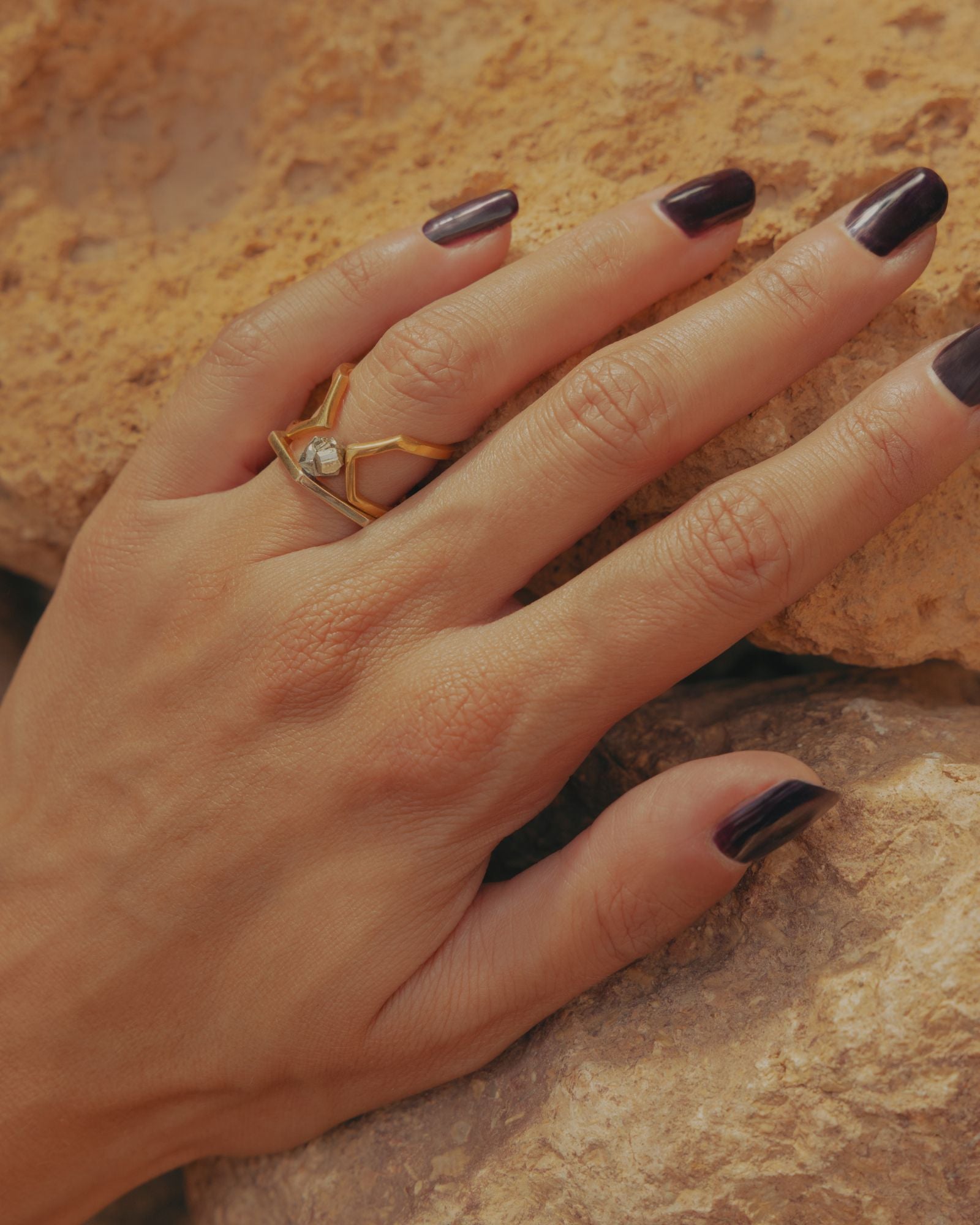 Photo gros plan d'une bague éthique portée à la main, modèle dualité moyenne en vermeil, combinée au modèle solitaire en vermeil et pyrite.
