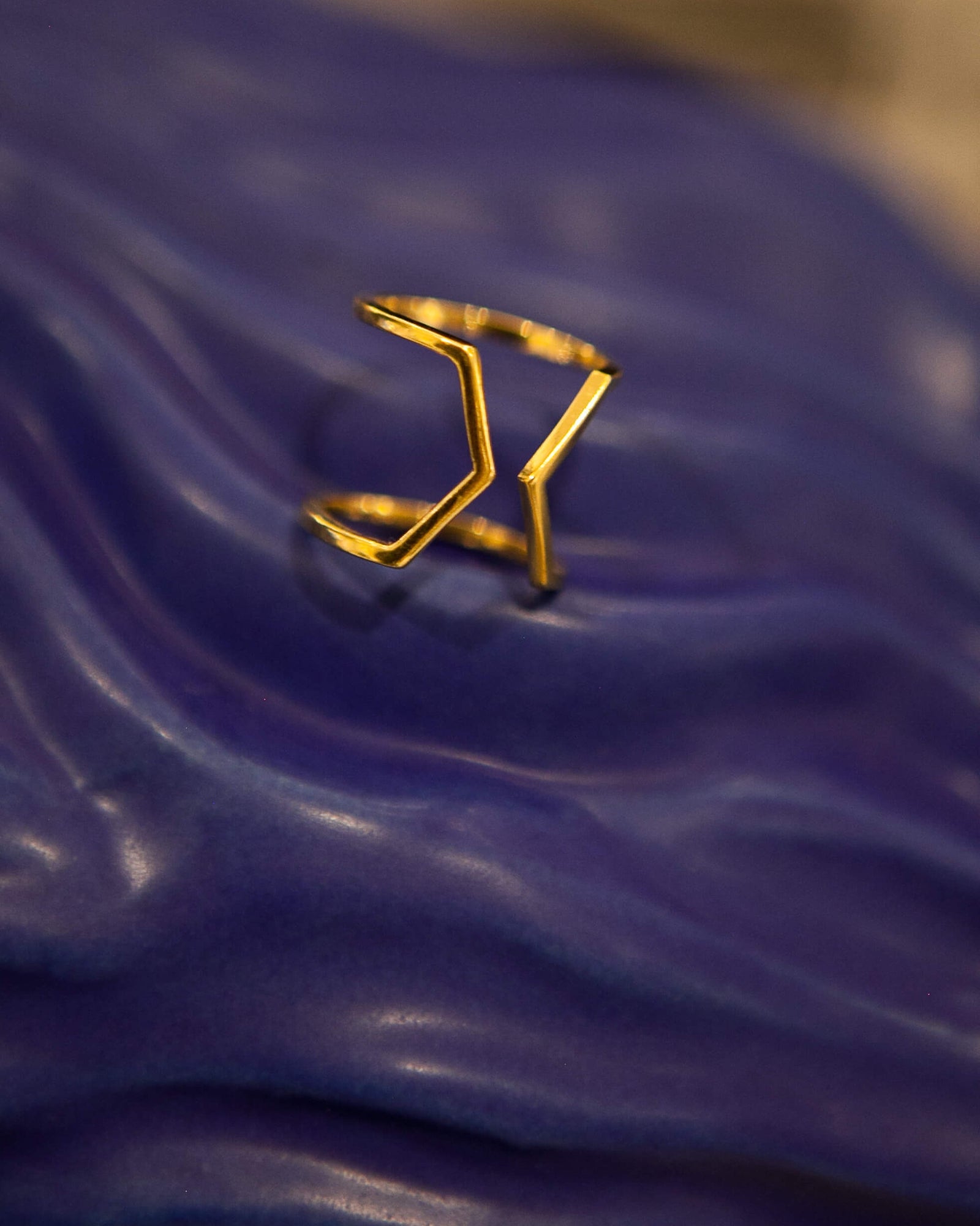 Photo du modèle de bague éthique Dualité large en vermeil non portée sur fond céramique vagues bleues