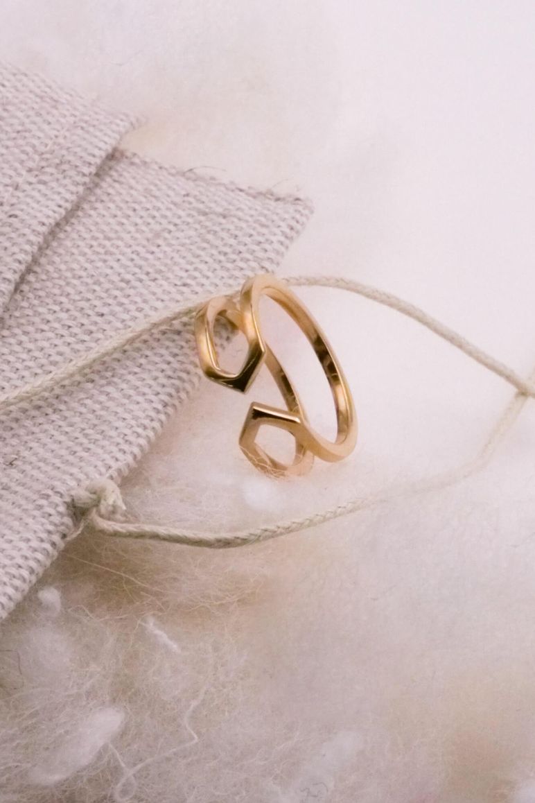 Photo d'une bague éthique modèle Dualité fine en vermeil sur un pochon et de la ouate tout deux des éléments du packaging durable.