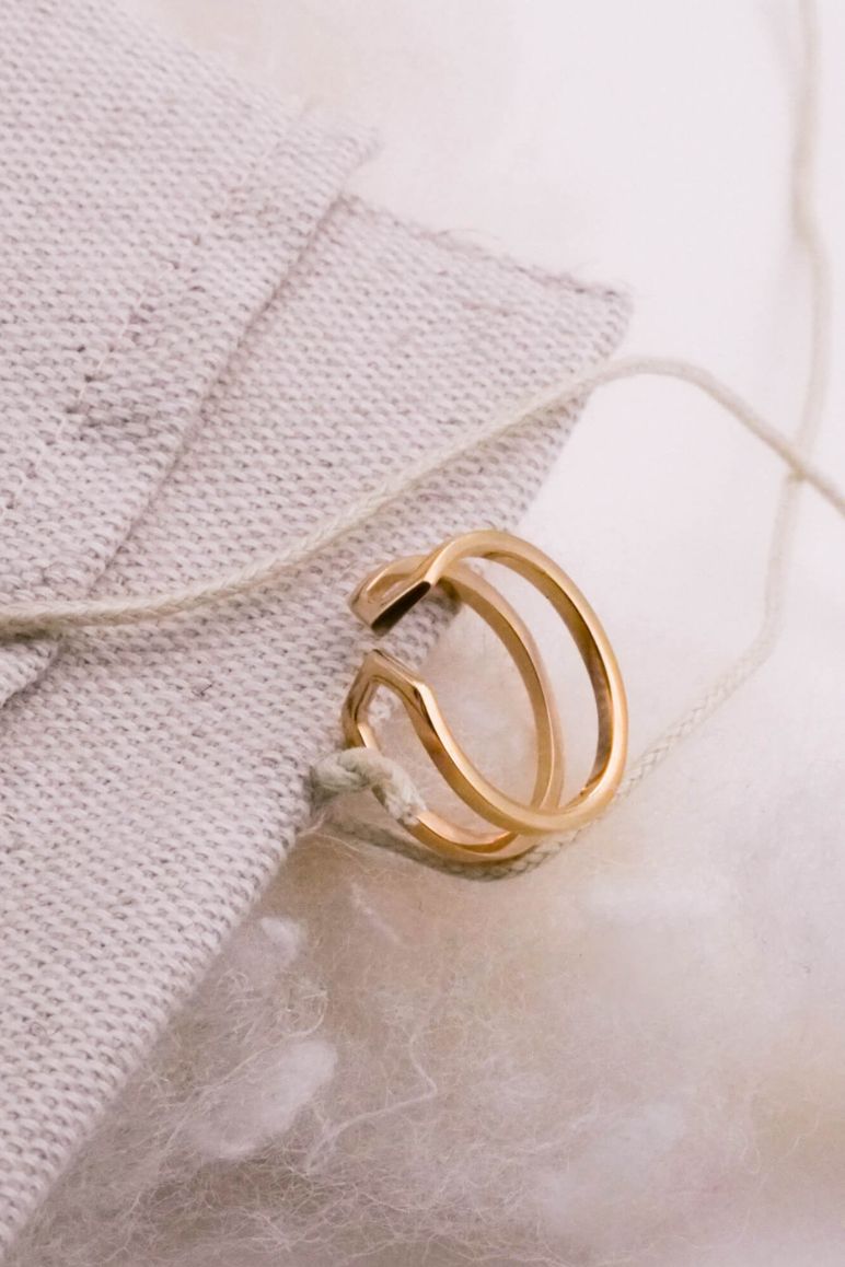 Photo d'une bague éthique modèle Dualité fine en vermeil sur un pochon et de la ouate tout deux des éléments du packaging durable.