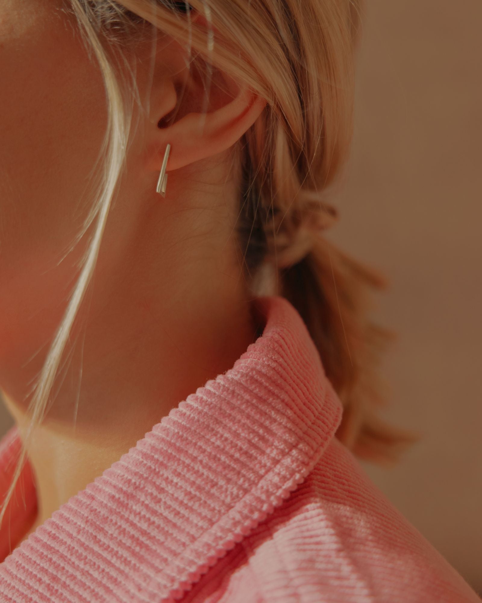 Photo portée d'une boucle d'oreille éthique modèle Mouvement en argent labellisé.