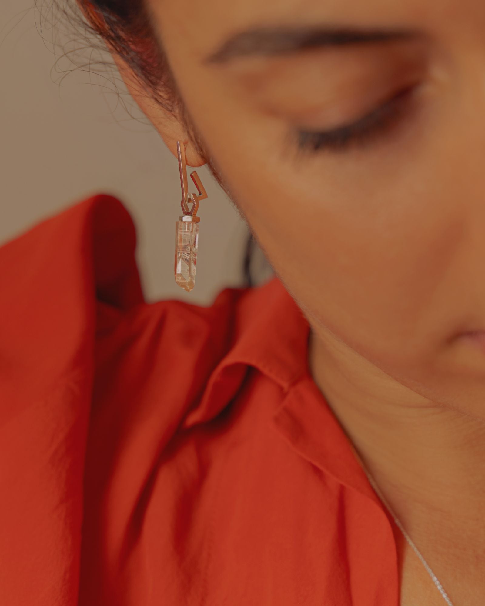 photo portée à l'oreille sur une boucle en argent d'un pendentif éthique made in france modèle Infime en argent labellisé et pierre quartz français.