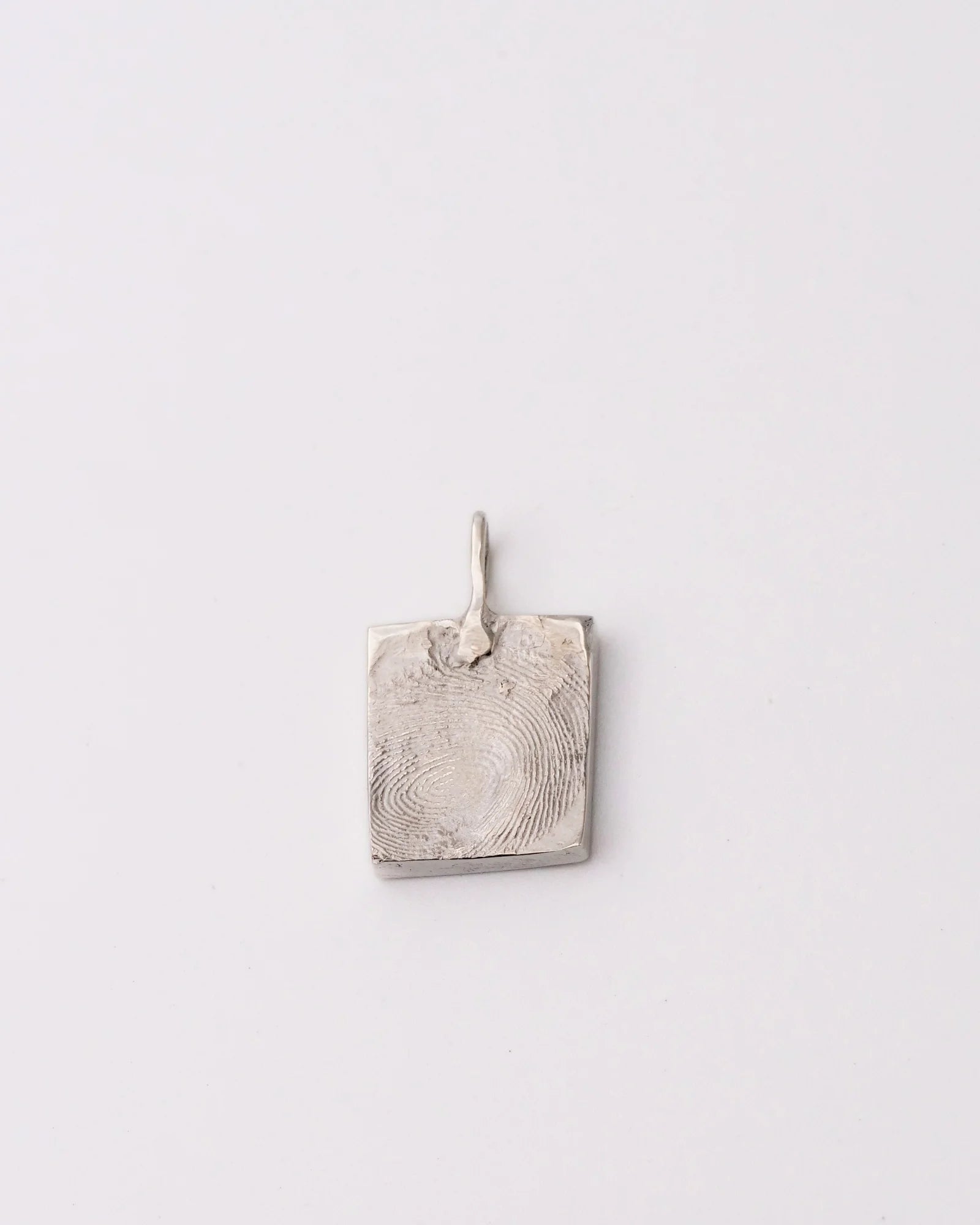 Pendentif carré argent avec empreinte digitale.