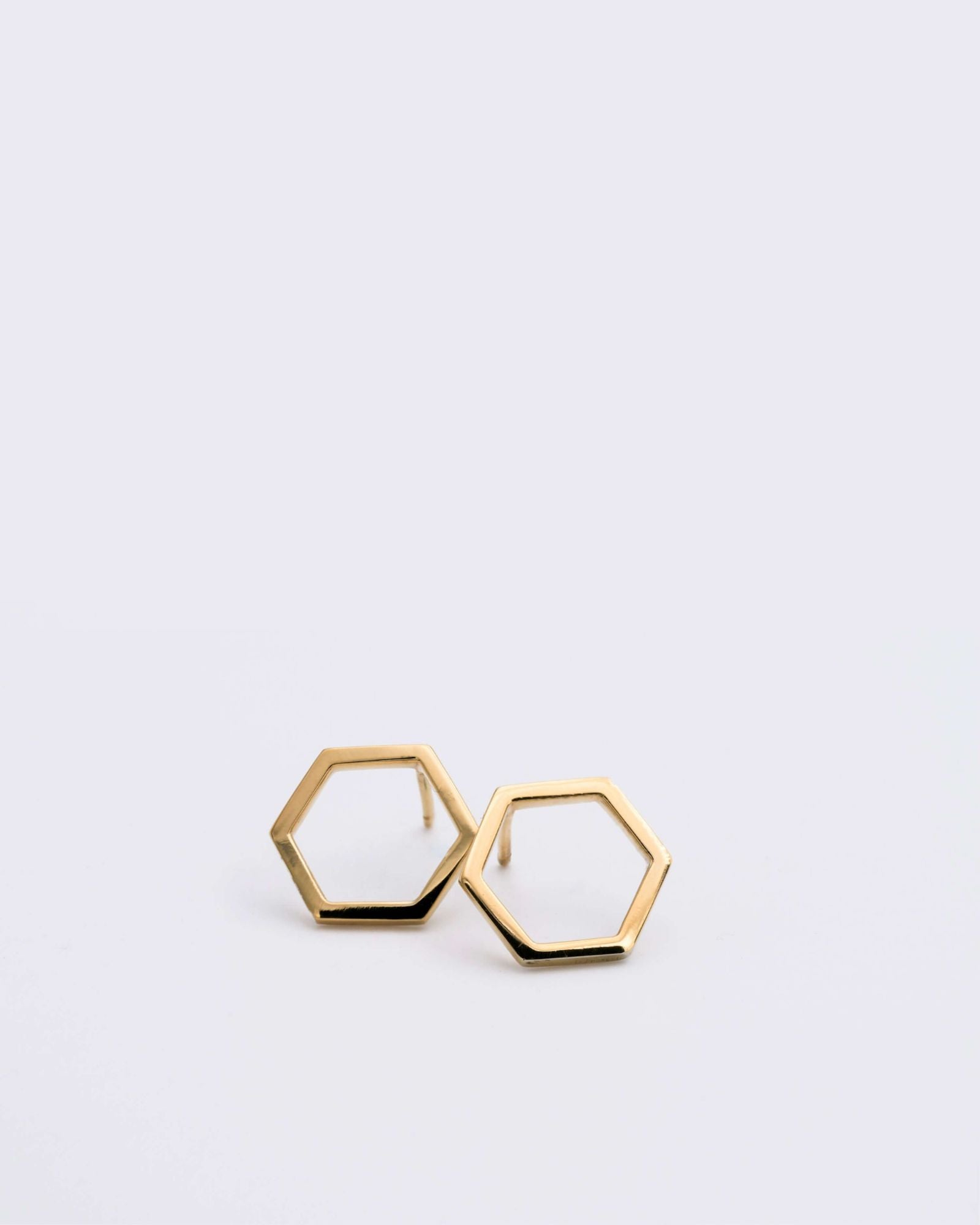 Boucles d'oreilles éthiques modèles Essentiel 14, forme hexagonale en or jaune non portées sur fond blanc.