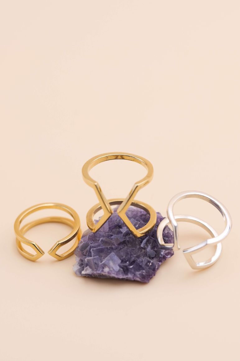 Photo d'un trio de bagues éthiques modèles Dualité, large en vermeil, moyenne en argent et fine en vermeil, non portée sur une fluorine brute.