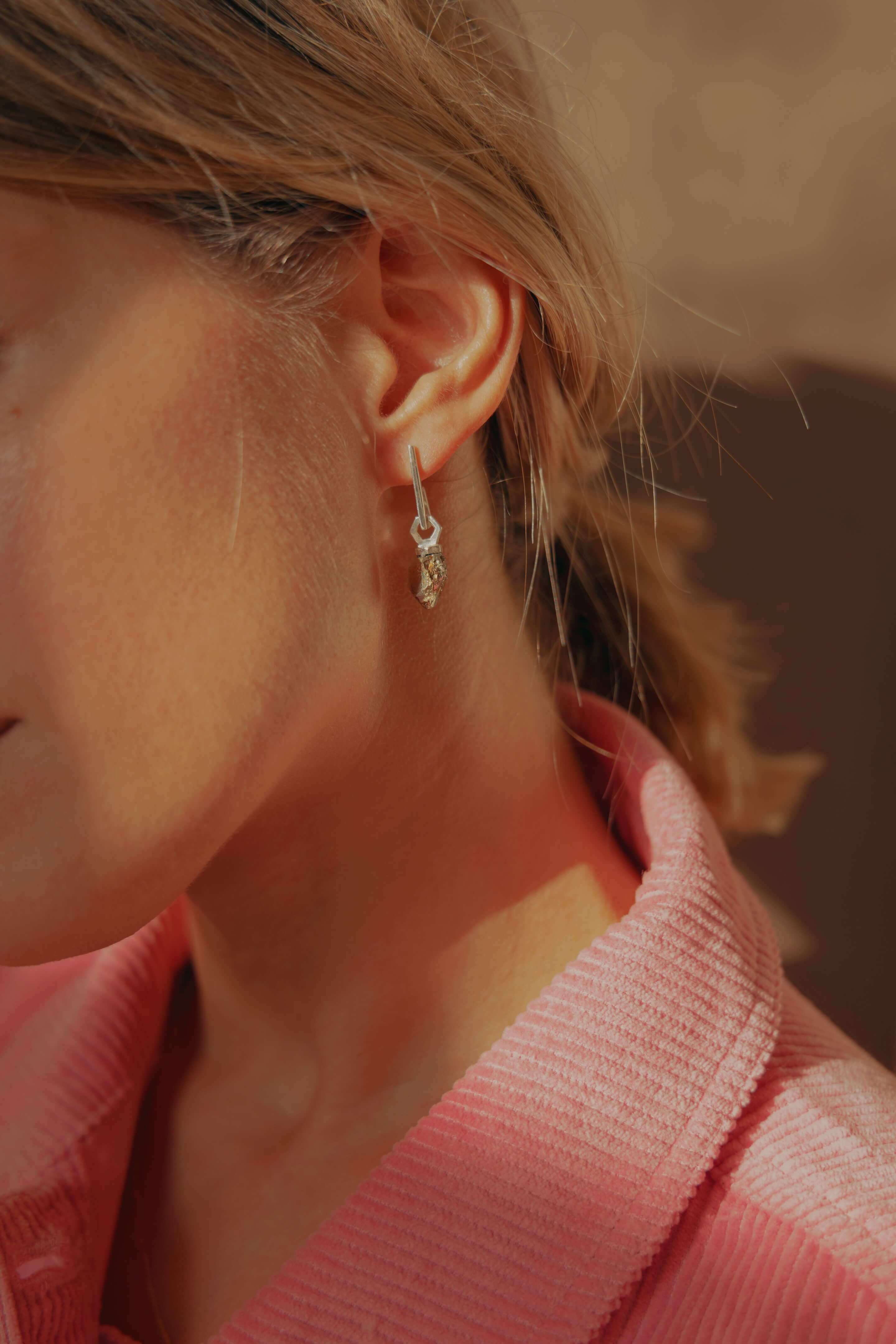 Photo d'une boucle d'oreille éthique modèle mouvement en argent labellisé, porté avec un pendentif éthique modèle Infime en argent labellisé et pyrite de France.
